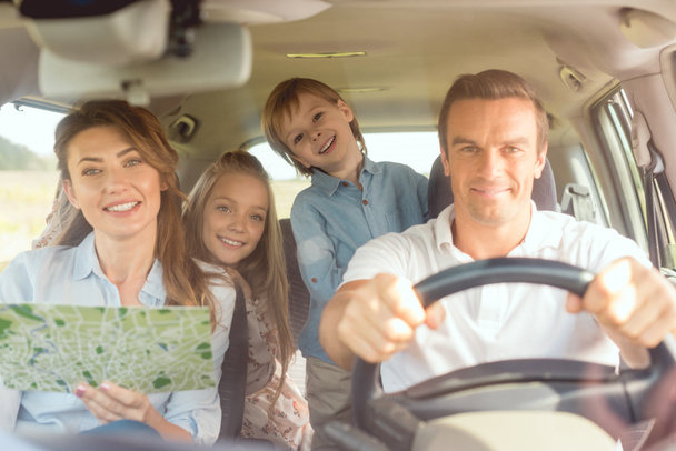 nézi a kamera autó utazás közben boldog fiatal család - Fotó, kép