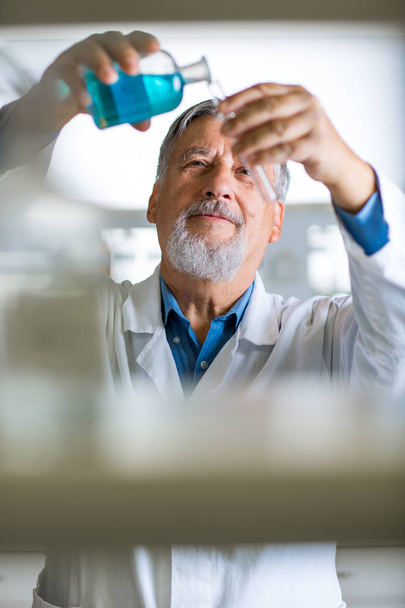 Senior male researcher carrying out scientific research in a lab (shallow DOF; color toned image) - Foto, Imagem