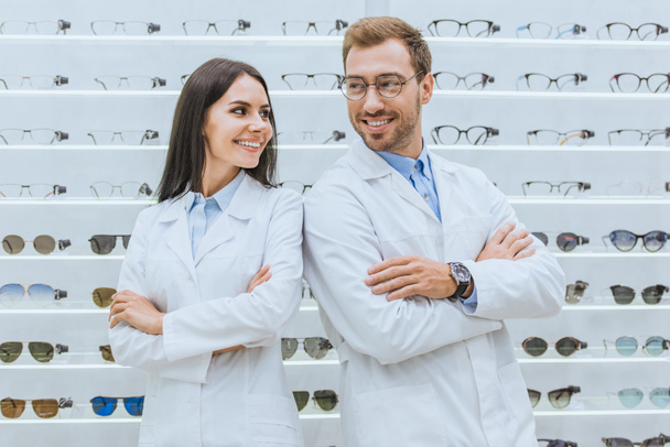 oculistes souriants professionnels debout avec les bras croisés en ophtalmologie
 - Photo, image