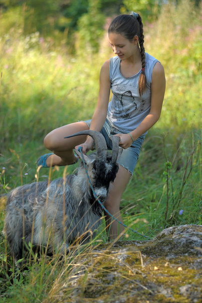 girl teenager and a gray goat outdoor - Fotografie, Obrázek