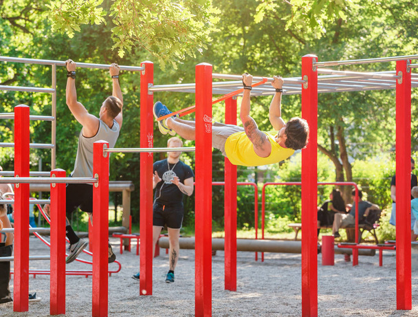22 MAY 2018, LEIPZIG, GERMANY: A lot of people go in for sports and fitness on a special equipped gym outdoors in city park, healthy lifestyle concept - Foto, imagen
