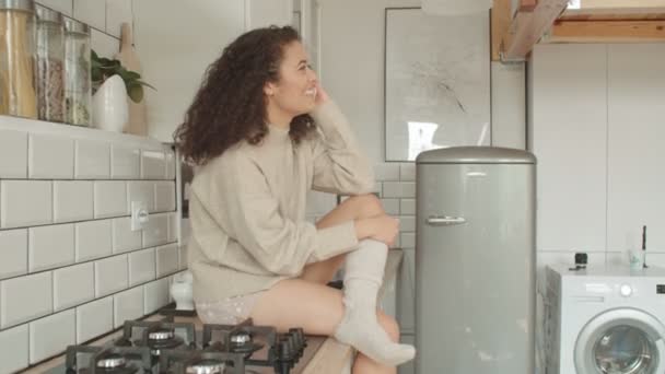 Young woman using mobile phone in kitchen. - Filmagem, Vídeo