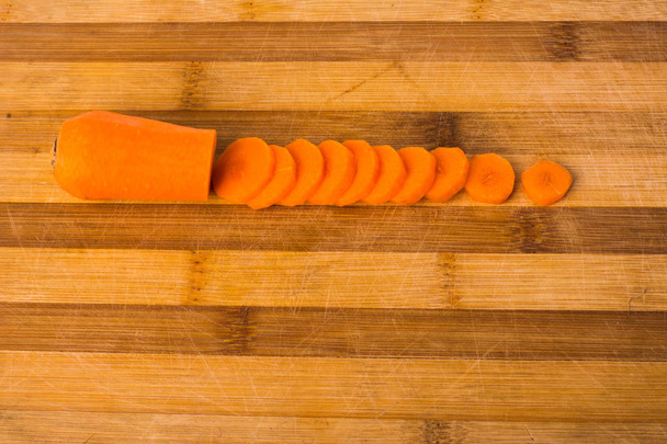 sliced carrots on a wooden background - Foto, afbeelding