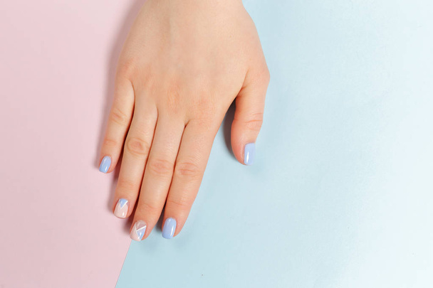 stylish trendy manicure on female hand on two-tones background. - Foto, Imagen