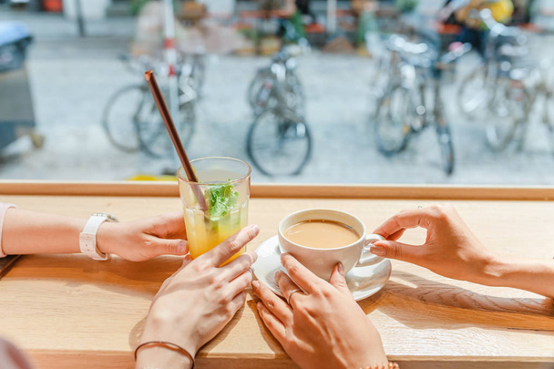 Kaksi onnellista tyttöä lounaalla kahvilassa, juomassa kahvia ja puhumassa. Ystävyys ja elämäntapa käsite
 - Valokuva, kuva