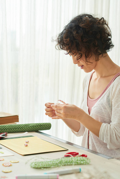 Pretty Japanese woman with curly hair enjoying gluing  - Photo, Image