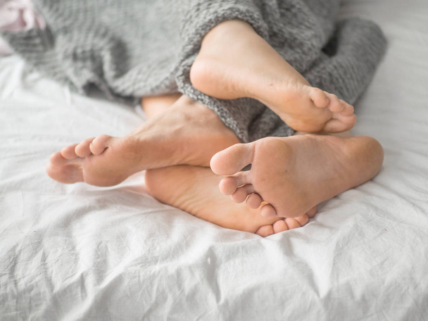 Couple in bed playing footsie. Love and relationship concept. - Foto, immagini