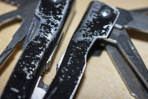 Close-up van multifunctionele gevouwen mes op houten achtergrond - Foto, afbeelding