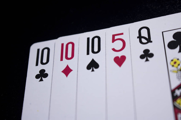 τρία από ένα είδος πόκερ κάρτα στο σκοτάδι μαύρο φόντο - Φωτογραφία, εικόνα