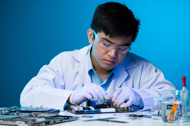 Jeune ingénieur asiatique travaillant avec des composants électroniques
 - Photo, image