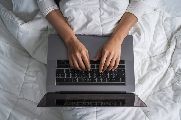 closed-up woman using a laptop computer on bed - 写真・画像