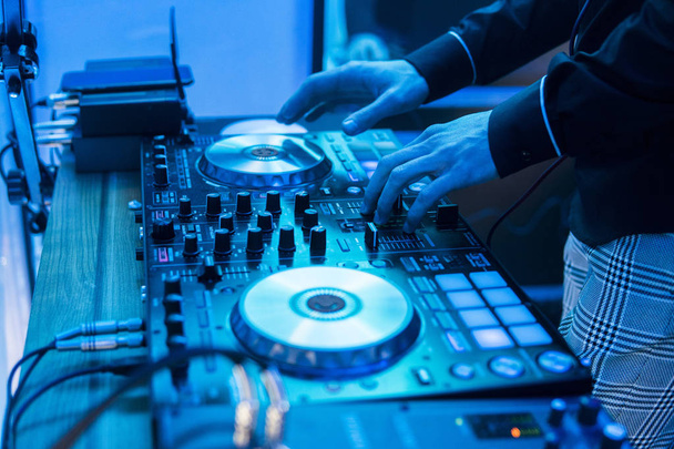 DJ plays and mix music on digital mixer controller. Close-up DJ performance controller, digital midi turntable system, adjustable torque, aluminum-turntable platter, fader, knob and slider, button. - Foto, imagen