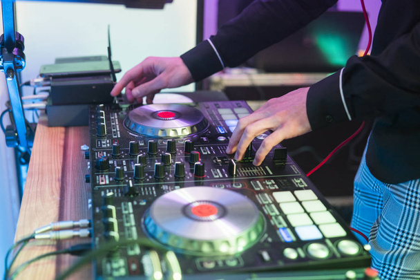 DJ reproduce y mezcla música en el controlador de mezclador digital. Controlador de rendimiento DJ de primer plano, sistema de mesa giratoria midi digital, par ajustable, plato giratorio de aluminio, fader, perilla y control deslizante, botón
. - Foto, imagen