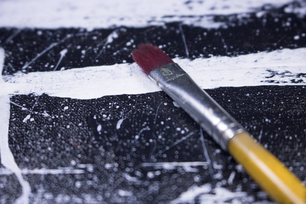 paint brush on grungy black and white acrylic paint canvas - Photo, Image