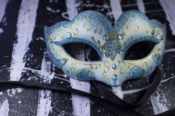 witte blauwe glitter diamant maskerade masker partij op zwarte en witte acrylverf doek - Foto, afbeelding