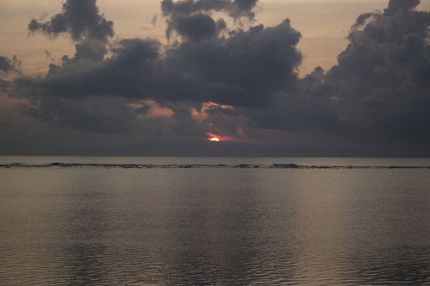 schilderachtig uitzicht op de Oceaan tijdens zonsondergang tijd met bewolkte hemel op achtergrond - Foto, afbeelding