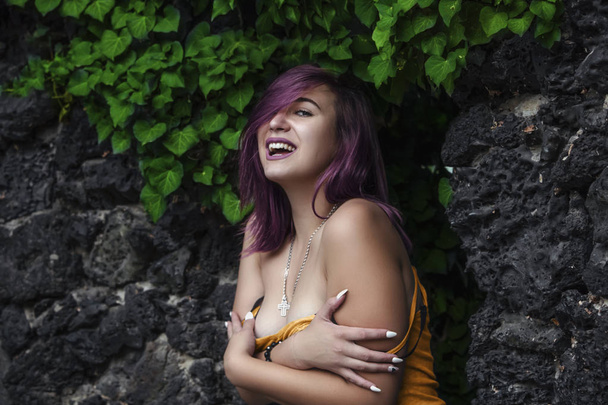красива молода дівчина з фіолетовим волоссям прикриває її голі груди і сміється з її ротом широко відкритим
 - Фото, зображення