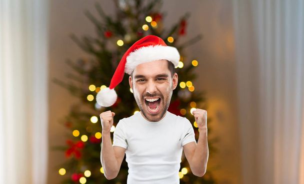 man celebrating victory over christmas tree - Zdjęcie, obraz