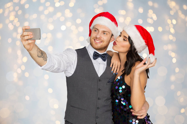 couple in santa hats taking selfie at christmas - Fotoğraf, Görsel