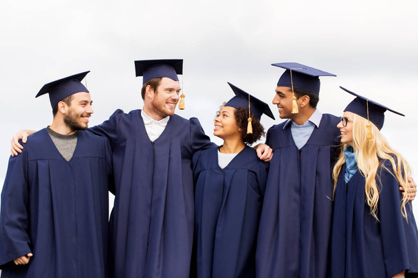 happy students or bachelors in mortar boards - Photo, Image