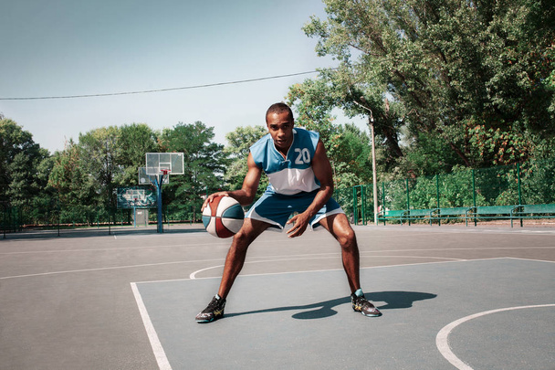 Picture of young confused african basketball player practicing - Фото, зображення