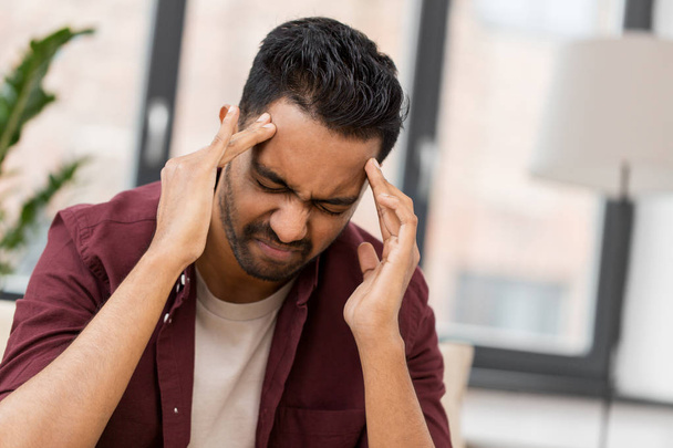 unhappy man suffering from head ache at home - Foto, immagini