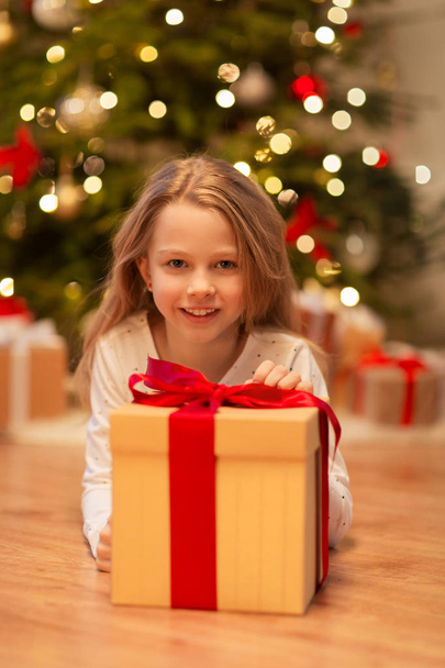smiling girl with christmas gift at home - Φωτογραφία, εικόνα