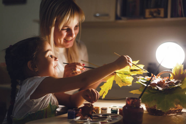 moeder en dochter herfstbladeren schilderen - Foto, afbeelding
