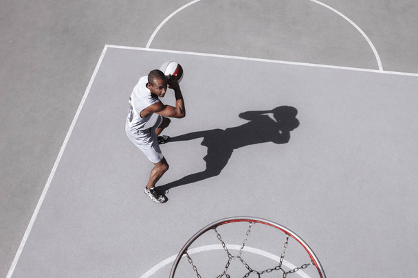 Picture of young confused african basketball player practicing - Фото, изображение