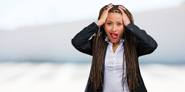 Portrait of a young black business woman frustrated and desperate, angry and sad with hands on head - Photo, Image