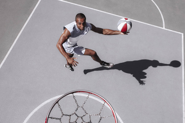 Bild eines jungen verwirrten afrikanischen Basketballspielers beim Üben - Foto, Bild
