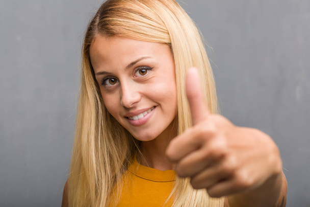 retrato de jovem loira natural sorrindo e levantando o polegar
 - Foto, Imagem
