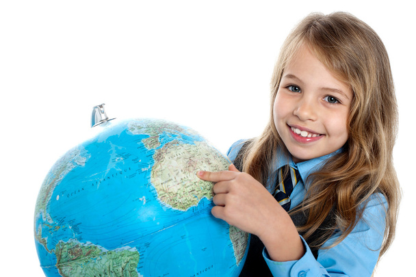 Pretty school child holding globe and pointing - Zdjęcie, obraz