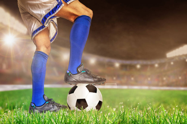 Ποδοσφαιριστής σε δράση με το ποδόσφαιρο σε φωτεινά υπαίθριο γήπεδο. Επικεντρωθεί σε πρώτο πλάνο και το ποδόσφαιρο μπάλα με ρηχό βάθος πεδίου στο φόντο και αντίγραφο χώρου. - Φωτογραφία, εικόνα