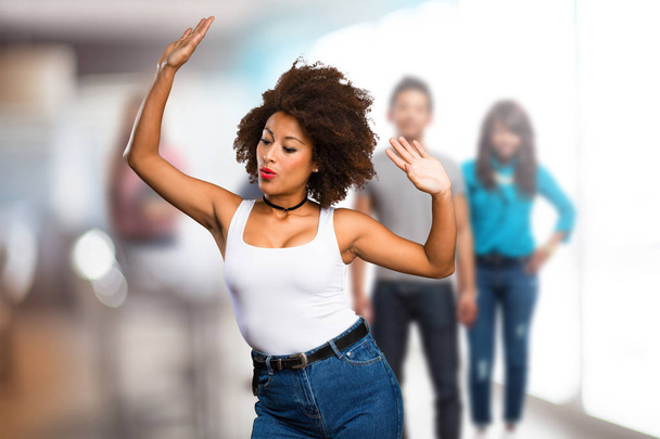 giovane donna nera che balla con persone sfocate sullo sfondo
 - Foto, immagini