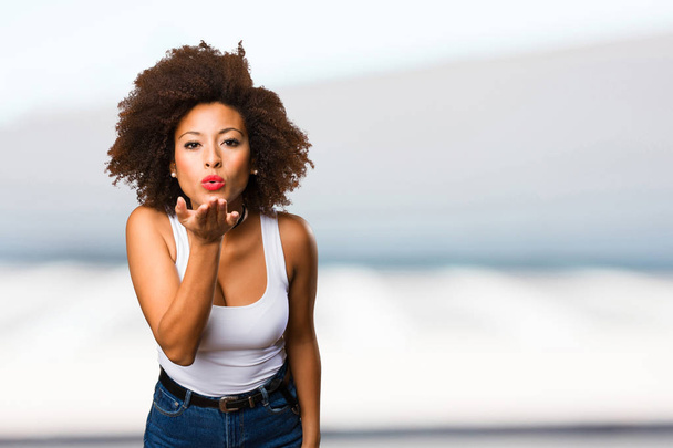 joven negro mujer enviando besos en borrosa fondo
 - Foto, Imagen