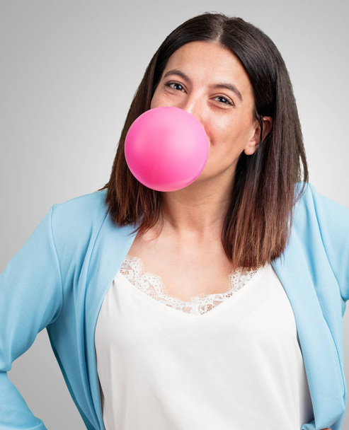 Mujer de mediana edad feliz y alegre, encerrando un globo de goma de mascar, concepto muy juguetón y dulce, divertido
 - Foto, Imagen