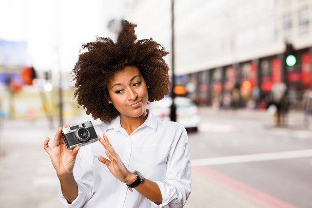 молода чорна жінка використовує старовинну камеру на розмитому фоні
 - Фото, зображення