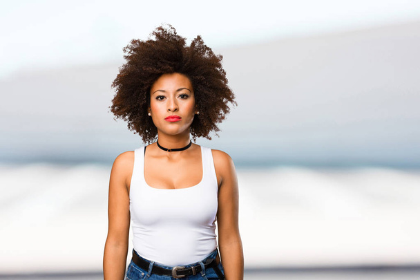 young black woman standing on blurred background - 写真・画像