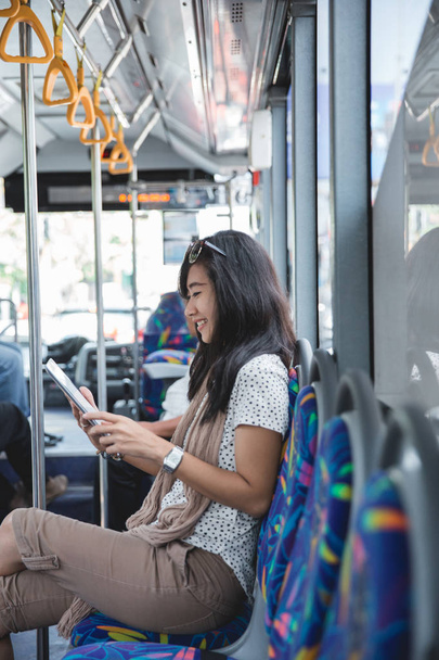 Young asian woman using her digital tablet on the bus - Φωτογραφία, εικόνα