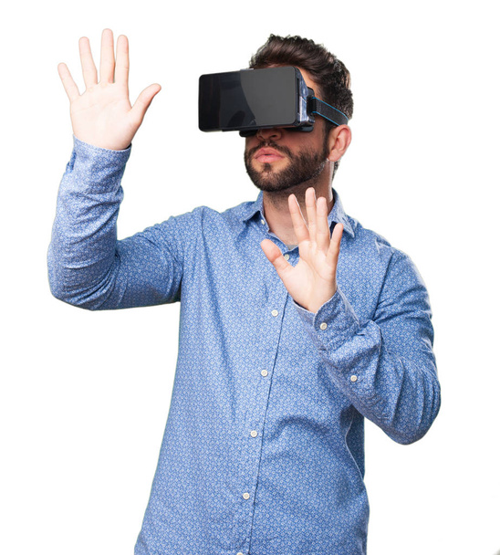 young man looking through virtual reality glasses isolated on white background - Valokuva, kuva