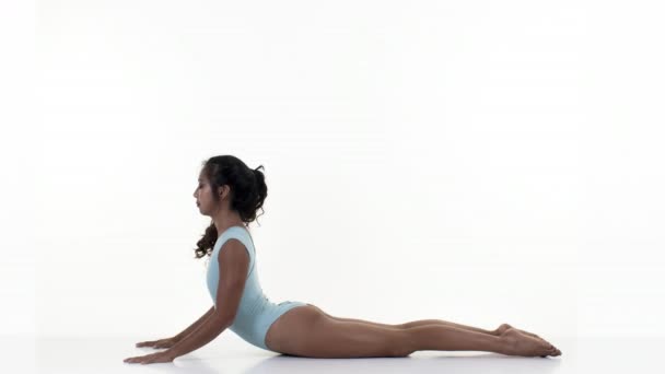 Beyaz zemin üzerine germe ve jimnastik egzersizleri yapıyor kadın - Video, Çekim