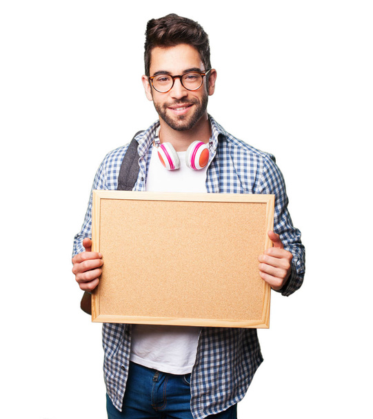 student man holding a corkboard isolated on white background - Foto, Imagen