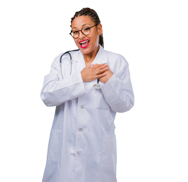 Portrait of a young black doctor woman doing a romantic gesture, in love with someone or showing affection for some friend - Foto, afbeelding