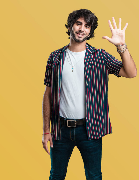 Nuori komea mies osoittaa numero viisi, symboli laskenta, käsite matematiikan, luottavainen ja iloinen
 - Valokuva, kuva