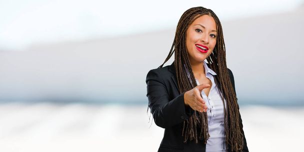 Portrait d'une jeune femme d'affaires noire tendre la main pour saluer quelqu'un ou geste pour aider, heureux et excité
 - Photo, image