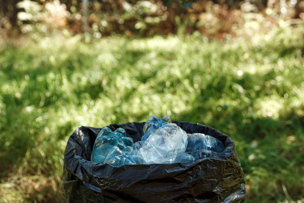 Used plastic bottles are stored in black bags for recycle. - Valokuva, kuva
