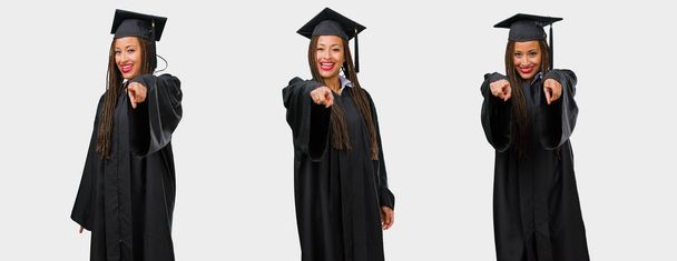 Набор выпускников молодая черная женщина весело и улыбаясь указывая на фронт
 - Фото, изображение