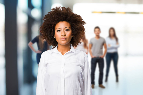 giovane donna nera in piedi con persone sfocate in background
 - Foto, immagini