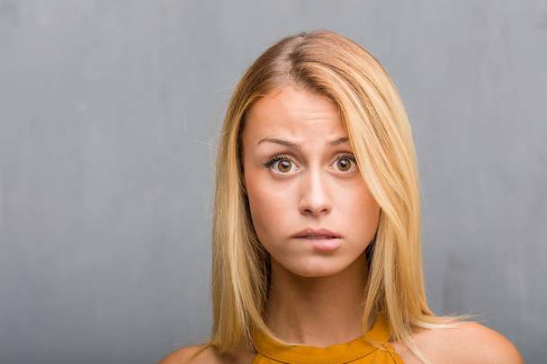 Porträt einer natürlichen jungen blonden Frau besorgt und überwältigt - Foto, Bild